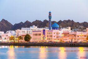 Oman, Muscat. Cityscape of Mutrah harbour, at dusk